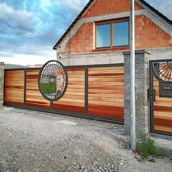 Sliding gate in a family house - hand-forged gate in combination with cedar wood