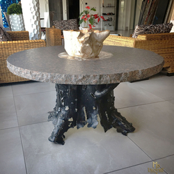 A hand wrought iron table of a tree bark design