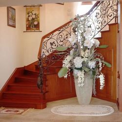 A romantic wrought iron railing with a wooden handrail