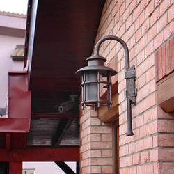 A hand wrought iron lamp with a shade