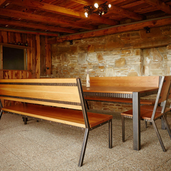 Modern wrought iron benches with a table in a combination with red spruce in a summer house of a family house