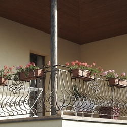 Kované zábradlie na balkóne rodinného domu s držiakmi kvetináčov