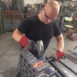 Umelecký kováč pri príprave dubových lístkov v kováčskej dielni