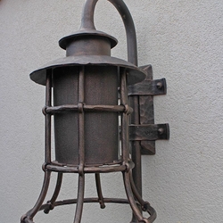 A wrought iron lamp with a shade