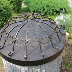 A wrought iron well cover
